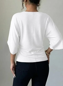 Rear view of white V-neck top showing loose short sleeves and centered back seam detail