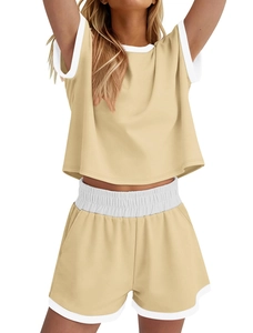 Détail du col crop top et de la taille du short avec liseré blanc sur ensemble beige