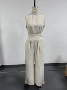 Detail of beige high neck sleeveless jumpsuit with textured fabric and wide waistband