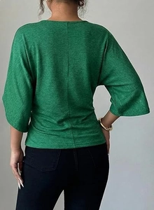 Macro detail of dark green waffle knit texture and vertical back seam on a slim-fit shirt