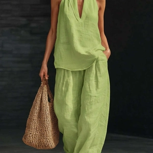 Dettaglio del set con top allacciato al collo e pantaloni larghi in lino verde