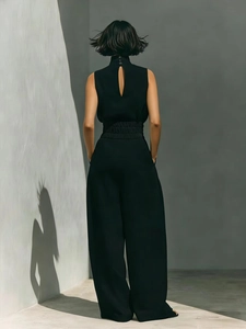 Detail of elegant black sleeveless jumpsuit with teardrop back cutout and high neckline