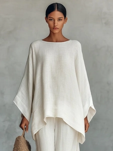 Detalle de las mangas murciélago oversize y la textura de lino natural del conjunto blanco