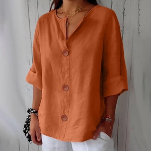 Detail of burnt orange v-neck linen t-shirt with large buttons and folded sleeves