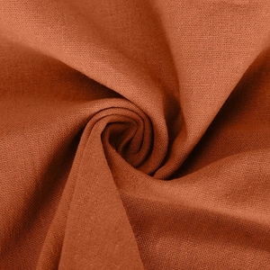 Detailed macro view of dark orange cotton linen fabric with soft draped texture