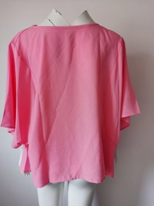 Detail of pink chiffon blouse showing the textured crepe fabric and loose batwing sleeve