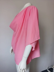 Detail view of pink loose chiffon blouse with draped V-neck on a white mannequin