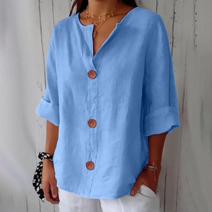 Detail of sky blue V-neck linen shirt featuring wood-grain buttons and textured fabric