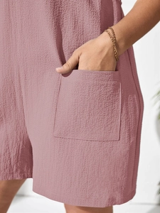 Detail shot of the square side pocket and textured crinkle fabric on dusty pink jumpsuit