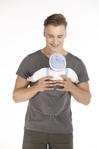 Detail of newborn baby doll wearing blue and white apparel held by father