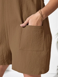 Close-up of brown textured romper with square patch pocket and waffle fabric detail