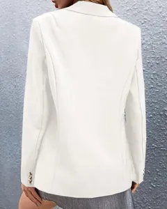 Detail of white blazer sleeves featuring three ornate gold embossed metal buttons