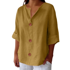 Detail of mustard yellow linen shirt with V-neckline and dark wood buttons