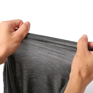 Detail shot showing the high elasticity of the grey knitted fabric in a close-up view