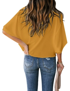 Rear view of ginger yellow chiffon batwing sleeve top paired with blue ripped jeans