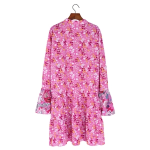 Détail d'une robe rose à imprimé fleuri avec poignets à volants et tissu léger d'été