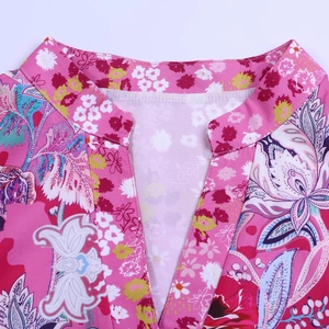 Détail de l'encolure en V et du motif paisley floral sur la robe d'été rose