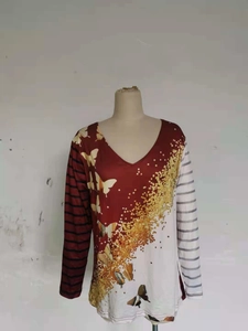 Dettaglio della maglia a maniche lunghe con scollo a V, stampa farfalla e righe