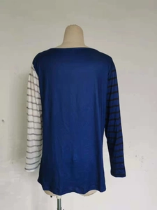 Dettaglio di maglia a maniche lunghe con strisce asimmetriche e corpo blu scuro elegante