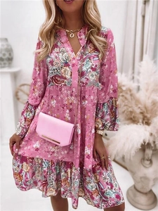 Détail de la robe fleurie rose avec jupe à volants superposés et manches évasées