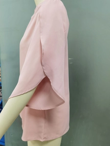 Detail view of pink chiffon top featuring elegant ruffle petal slit sleeves and soft texture
