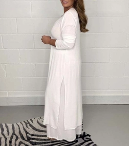 Détail de l'ensemble blanc haut à manches longues et pantalon avec fente latérale