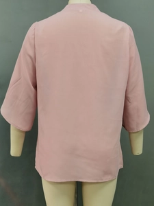 Detail view of pink chiffon top featuring petal flare sleeves and a loose casual fit