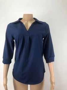 Detalle de la blusa de gasa azul marino con cuello en V y elegante diseño plisado