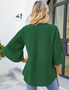 Detail view of dark green chiffon top with bell sleeves and elegant V-neckline
