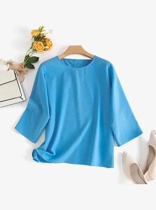 Mise à plat d'une blouse décontractée turquoise à col rond avec des manches à sept points