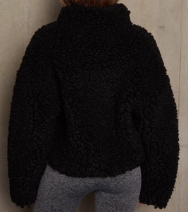 Rear view of black sherpa jacket showing plush teddy texture and stand collar detail