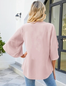 Rear view of pink chiffon top featuring bell sleeves and curved hemline details