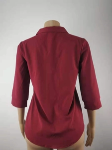 Detalle de la espalda de una blusa de gasa granate con dobladillo redondeado y cuello