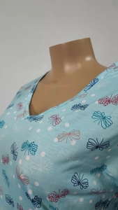 Detail van lichtblauwe nachtkleding met V-hals, vlinderpatroon en witte kleine stippen