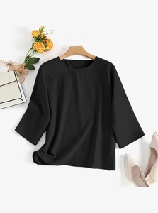 Mise à plat d'une blouse noire à col rond et manches 3/4 sur un cintre en bois