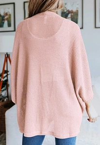 Rückansicht eines locker sitzenden pfirsichfarbenen Cardigans mit modernem Waffelstrickmuster