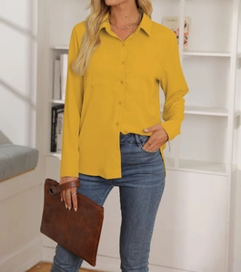 Dettaglio di una camicia a maniche lunghe giallo zenzero con colletto e taschino