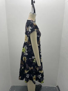 Close-up of black floral tiered dress with yellow and white flowers and ruffle sleeves
