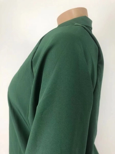 Detalle de blusa de gasa verde oscuro que muestra el cuello alto y costura del hombro
