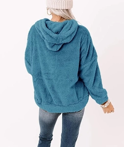 Detailed back view of a fuzzy turquoise hooded sweatshirt with soft sherpa texture
