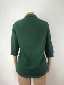 Detalle de la parte posterior de una elegante blusa de gasa verde oscuro con cuello en V