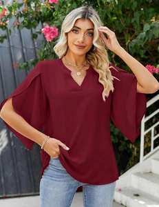 Detail of burgundy V-neck chiffon top with elegant layered ruffle sleeves in nature
