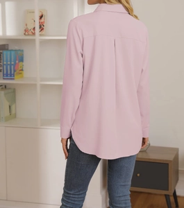 Dettaglio camicia rosa a maniche lunghe con piega posteriore e bordo curvo alla moda