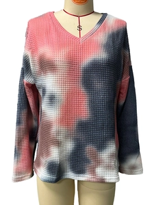 Macro detail of V-neck tie-dye waffle knit texture and fabric pattern on the long sleeve top