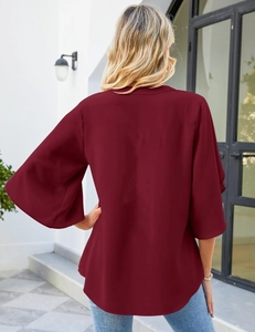 Detail of burgundy chiffon blouse showing elegant bell sleeves and loose fit silhouette