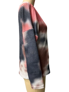 Detailed side view of the waffle knit texture and pink tie-dye pattern on the long sleeve top