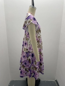 Detail of floral tiered dress featuring purple flower print and ruffle cap sleeves on mannequin