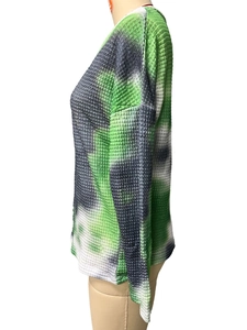 Side view of waffle knit long sleeve top featuring green tie-dye camouflage pattern