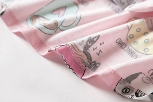 Detail van roze katoenen pyjama met cartoonprints en nette afwerking van de zoom