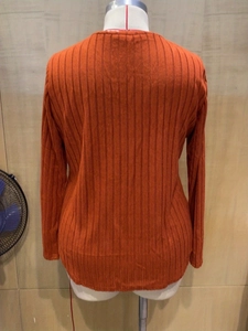Close-up of the ribbed knit texture and back stitching of the V-neck long sleeve top